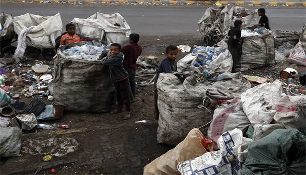 Crianças colectando bidons no lixo